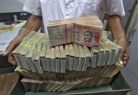 An employee poses with the bundles of Indian rupee notes inside a bank in Agartala, the capital of India's northeastern state of Tripura Aug An employee poses with the bundles of Indian rupee notes inside a bank in Agartala, the capital of India's northeastern state of Tripura Aug