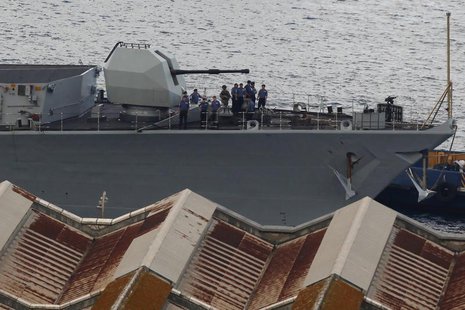 Members of the British Royal Navy frigate HMS Westminster stand next to a heavy weapon as they are towed towards the port after arriving at Members of the British Royal Navy frigate HMS Westminster stand next to a heavy weapon as they are towed towards the port after arriving at