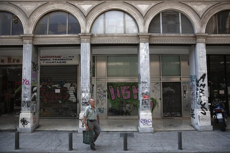 A man carries shopping bags on a street with closed shops in Athens August 12, 2013. REUTERS/Yorgos Karahalis A man carries shopping bags on a street with closed shops in Athens August 12, 2013. REUTERS/Yorgos Karahalis