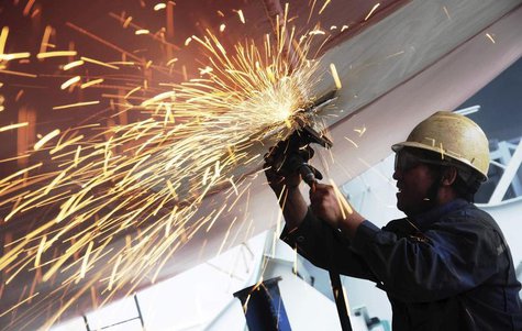 A labourer polishes the bottom of a cargo ship at a shipyard in Qingdao, Shandong province July 1, 2013. REUTERS/China Daily A labourer polishes the bottom of a cargo ship at a shipyard in Qingdao, Shandong province July 1, 2013. REUTERS/China Daily