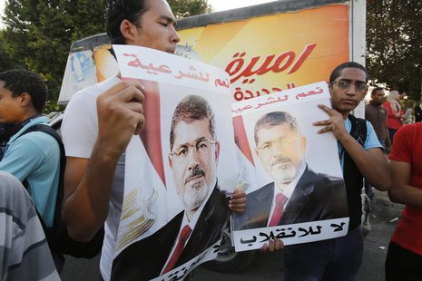 Supporters of deposed Egyptian President Mohamed Mursi hold up posters of him during a protest along Zahara street in Cairo August 18, 2013. Supporters of deposed Egyptian President Mohamed Mursi hold up posters of him during a protest along Zahara street in Cairo August 18, 2013.