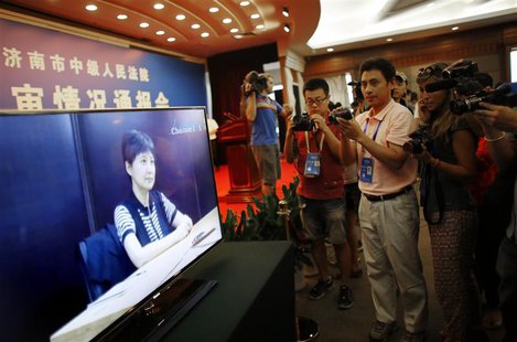 Journalists take pictures and videos of a screen displaying a court's microblog page showing a video of Gu Kailai, wife of ousted Chinese Co Journalists take pictures and videos of a screen displaying a court's microblog page showing a video of Gu Kailai, wife of ousted Chinese Co