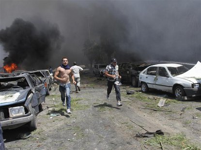 People run to help outside one of two mosques hit by explosions in Lebanon's northern city of Tripoli, August 23, 2013. REUTERS/Omar Ibrahim People run to help outside one of two mosques hit by explosions in Lebanon's northern city of Tripoli, August 23, 2013. REUTERS/Omar Ibrahim