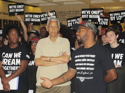 Julian Bond, former NAACP chairman (C), listens as Phillip Agnew, executive director of the Dream Defenders (R), announces an end of a 31-da Julian Bond, former NAACP chairman (C), listens as Phillip Agnew, executive director of the Dream Defenders (R), announces an end of a 31-da
