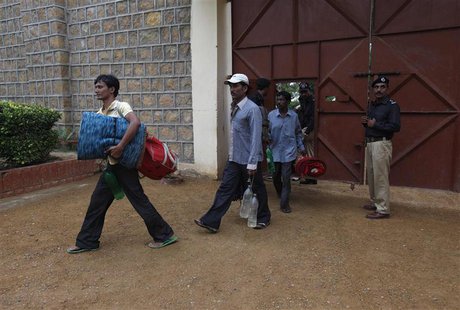Fishermen from India carry their belongings as they walk out from a gate before their release, at Karachi's District Malir prison, August 23 Fishermen from India carry their belongings as they walk out from a gate before their release, at Karachi's District Malir prison, August 23