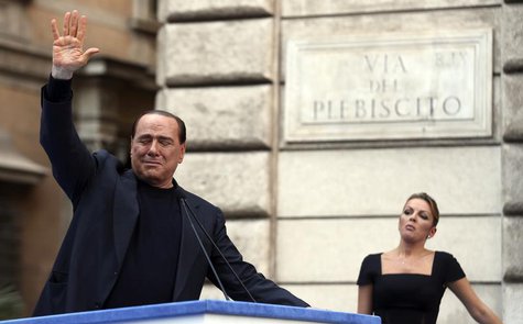 Former Italian Prime Minister Silvio Berlusconi waves to supporters as his girlfriend Francesca Pascale looks on during a rally to protest h Former Italian Prime Minister Silvio Berlusconi waves to supporters as his girlfriend Francesca Pascale looks on during a rally to protest h