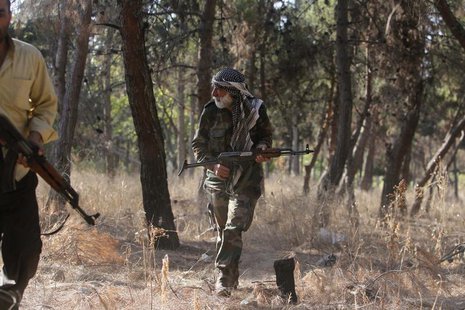 A member of the 'Liwaa Ahrar Suriya' brigade, operating under the Free Syrian Army, is seen in a public park that separates them and forces A member of the 'Liwaa Ahrar Suriya' brigade, operating under the Free Syrian Army, is seen in a public park that separates them and forces