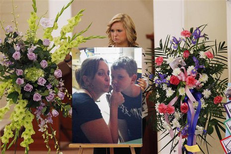 Hannah Anderson positions a photo of her mother Christina Anderson and brother Ethan Anderson on an easel at the memorial service in Guardia Hannah Anderson positions a photo of her mother Christina Anderson and brother Ethan Anderson on an easel at the memorial service in Guardia