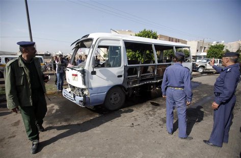 A policeman (L) and air force officers gather at the site of a bomb attack on a military bus in Sanaa August 25, 2013. REUTERS/Khaled Abdull A policeman (L) and air force officers gather at the site of a bomb attack on a military bus in Sanaa August 25, 2013. REUTERS/Khaled Abdull