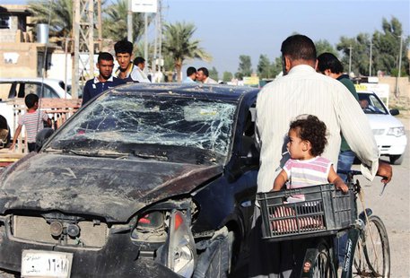 Residents pass by a damaged vehicle a day after a bomb attack in central Baquba, 65 km (40 miles) northeast of Baghdad, August 25, 2013. REU Residents pass by a damaged vehicle a day after a bomb attack in central Baquba, 65 km (40 miles) northeast of Baghdad, August 25, 2013. REU
