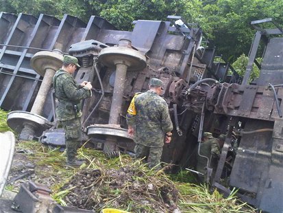 Soldiers stand near the overturned wagons of a derailed train in Huamanguillo, in this August 25, 2013 handout photo provided by Diario Pres Soldiers stand near the overturned wagons of a derailed train in Huamanguillo, in this August 25, 2013 handout photo provided by Diario Pres