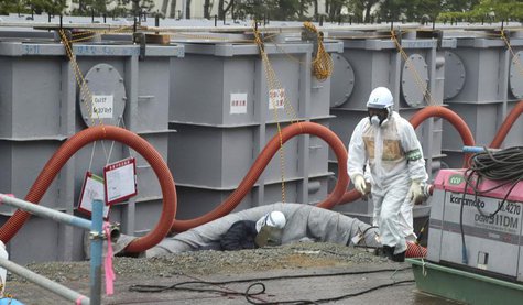 A worker walks in front of water tanks at Tokyo Electric Power Company's (TEPCO) tsunami-crippled Fukushima Daiichi nuclear power plant in F A worker walks in front of water tanks at Tokyo Electric Power Company's (TEPCO) tsunami-crippled Fukushima Daiichi nuclear power plant in F