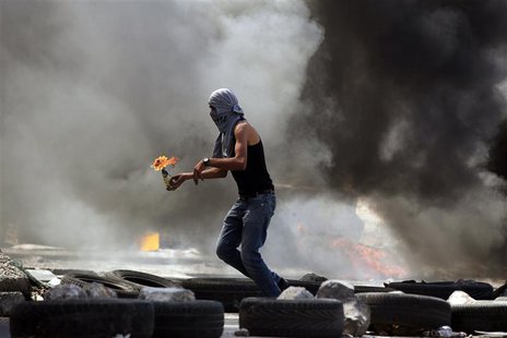 A Palestinian protester gets ready to throw a Molotov cocktail during small clashes with Israeli forces following the funerals of Robin Zaye A Palestinian protester gets ready to throw a Molotov cocktail during small clashes with Israeli forces following the funerals of Robin Zaye