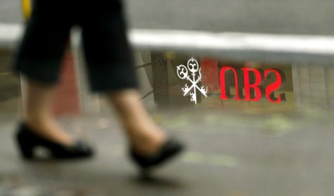 The logo of Swiss bank UBS is reflected in a puddle as a woman walks past, in Zurich July 30, 2013. REUTERS/Arnd Wiegmann The logo of Swiss bank UBS is reflected in a puddle as a woman walks past, in Zurich July 30, 2013. REUTERS/Arnd Wiegmann