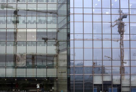 Cranes on a construction site are reflected on a business building in Beijing August 1, 2013. REUTERS/Kim Kyung-Hoon Cranes on a construction site are reflected on a business building in Beijing August 1, 2013. REUTERS/Kim Kyung-Hoon