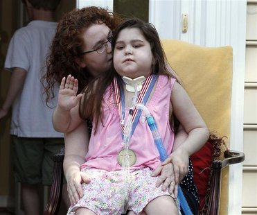 Sarah Murnaghan (R), an 11-year-old girl who underwent a double lung transplant, sits on her mother Janet's lap outside their home in Newtow Sarah Murnaghan (R), an 11-year-old girl who underwent a double lung transplant, sits on her mother Janet's lap outside their home in Newtow