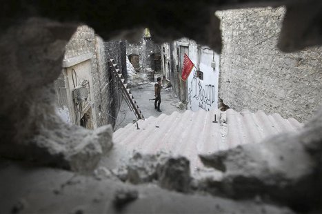 A Free Syrian Army is pictured through a hole in the old city of Aleppo August 27, 2013. REUTERS/Muzaffar Salman A Free Syrian Army is pictured through a hole in the old city of Aleppo August 27, 2013. REUTERS/Muzaffar Salman