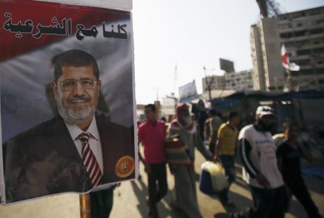 A poster of deposed Egyptian President Mohamed Mursi is seen as members of the Muslim Brotherhood and supporters of Mursi walk at Rabaa Adaw A poster of deposed Egyptian President Mohamed Mursi is seen as members of the Muslim Brotherhood and supporters of Mursi walk at Rabaa Adaw