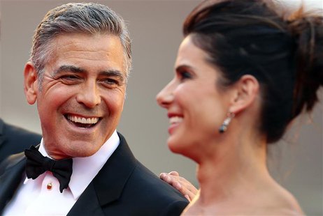 U.S. actor George Clooney (L) smiles next to actress Sandra Bullock as their arrive for the premiere of "Gravity" at the 70th Venice Film Fe U.S. actor George Clooney (L) smiles next to actress Sandra Bullock as their arrive for the premiere of "Gravity" at the 70th Venice Film Fe