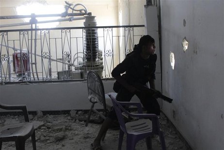 A Free Syrian Army fighter looks through a hole in a wall as he takes cover inside an electric company near Aleppo International airport Aug A Free Syrian Army fighter looks through a hole in a wall as he takes cover inside an electric company near Aleppo International airport Aug