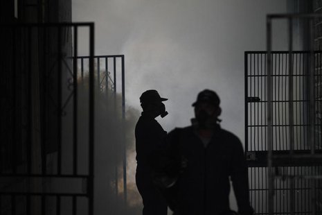 Health workers fumigate a school in Tegucigalpa August 9, 2013. REUTERS/Jorge Cabrera Health workers fumigate a school in Tegucigalpa August 9, 2013. REUTERS/Jorge Cabrera