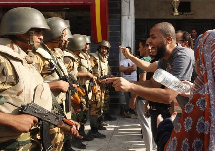 Supporters of ousted Egyptian President Mohamed Mursi argue with riot police and army personnel during clashes near Rabaa Adawiya square in Supporters of ousted Egyptian President Mohamed Mursi argue with riot police and army personnel during clashes near Rabaa Adawiya square in