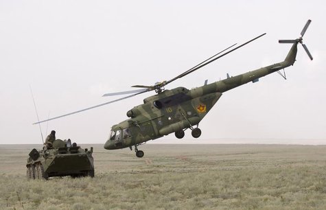An MI-17 helicopter flies by an armoured personnel carrier (APC) during the Steppe Eagle 2010 joint tactical military exercise at Ili milita An MI-17 helicopter flies by an armoured personnel carrier (APC) during the Steppe Eagle 2010 joint tactical military exercise at Ili milita