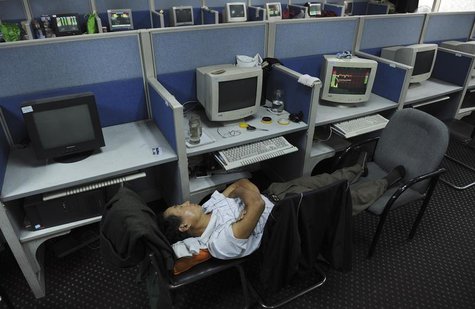 An investor sleeps on chairs next to a computer screen showing stock information at a brokerage house in Hefei, Anhui province June 13, 2013 An investor sleeps on chairs next to a computer screen showing stock information at a brokerage house in Hefei, Anhui province June 13, 2013