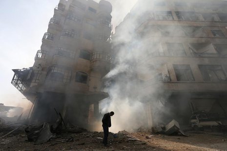A man walks in front of a burning building after a Syrian Air force air strike in Ain Tarma neighbourhood of Damascus in this January 27, 20 A man walks in front of a burning building after a Syrian Air force air strike in Ain Tarma neighbourhood of Damascus in this January 27, 20