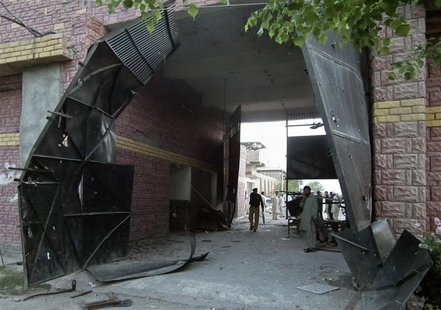 Security officials stand near a damaged jail gate after inmates escaped from the prison in the town of Bannu, northwest of Pakistan, in this Security officials stand near a damaged jail gate after inmates escaped from the prison in the town of Bannu, northwest of Pakistan, in this