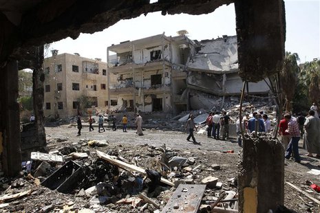 People inspect the damage at a site hit by what activists say was a car bomb in Raqqa province, eastern Syria August 29, 2013. REUTERS/Nour People inspect the damage at a site hit by what activists say was a car bomb in Raqqa province, eastern Syria August 29, 2013. REUTERS/Nour