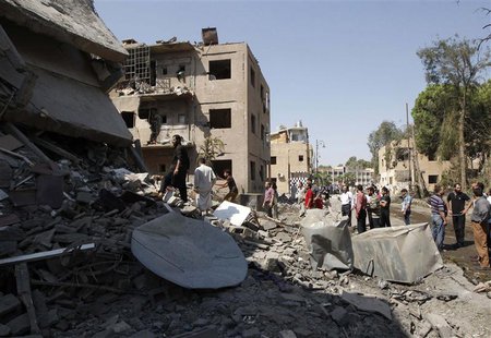 People look at the damage at a site hit by what activists say was a car bomb in Raqqa province, eastern Syria August 29, 2013. REUTERS/Nour People look at the damage at a site hit by what activists say was a car bomb in Raqqa province, eastern Syria August 29, 2013. REUTERS/Nour