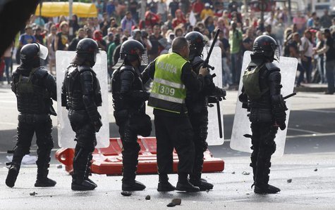 A police officer takes shelter behind the shields of his colleagues during a protest against the government of Colombian President Juan Manu A police officer takes shelter behind the shields of his colleagues during a protest against the government of Colombian President Juan Manu
