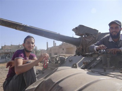 Free Syrian Army (FSA) fighters are seen at a tank that belonged to forces loyal to Syria's President Bashar al-Assad after the FSA said the Free Syrian Army (FSA) fighters are seen at a tank that belonged to forces loyal to Syria's President Bashar al-Assad after the FSA said the