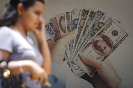 A customer walks past an advertisement for a foreign currency exchange facility at a bank in Mumbai August 19, 2013. REUTERS/Danish Siddiqui A customer walks past an advertisement for a foreign currency exchange facility at a bank in Mumbai August 19, 2013. REUTERS/Danish Siddiqui