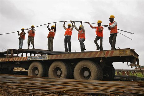Workers unload iron rods from a truck at the construction site of an educational institute on the outskirts of western Indian city of Ahmeda Workers unload iron rods from a truck at the construction site of an educational institute on the outskirts of western Indian city of Ahmeda