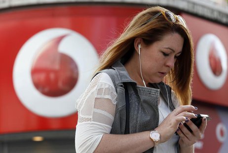 A woman talks on her mobile phone as she walks past a Vodafone store in London September 2, 2013 REUTERS/Stefan Wermuth A woman talks on her mobile phone as she walks past a Vodafone store in London September 2, 2013 REUTERS/Stefan Wermuth