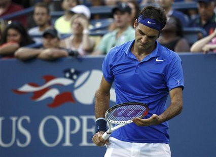 Roger Federer of Switzerland looks down at his racquet during the second set against Tommy Robredo of Spain at the U.S. Open tennis champion Roger Federer of Switzerland looks down at his racquet during the second set against Tommy Robredo of Spain at the U.S. Open tennis champion