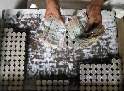 A man exchanging damaged Indian currency counts 100 rupee notes along a roadside in Kolkata August 30, 2013. REUTERS/Rupak De Chowdhuri A man exchanging damaged Indian currency counts 100 rupee notes along a roadside in Kolkata August 30, 2013. REUTERS/Rupak De Chowdhuri