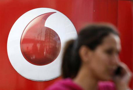 A woman talks on her mobile phone as she walks past a Vodafone store in London September 2, 2013. REUTERS/Stefan Wermuth A woman talks on her mobile phone as she walks past a Vodafone store in London September 2, 2013. REUTERS/Stefan Wermuth
