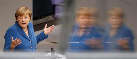 German Chancellor Angela Merkel is reflected in a window as she gives a speech during a debate of the lower house of parliament Bundestag in German Chancellor Angela Merkel is reflected in a window as she gives a speech during a debate of the lower house of parliament Bundestag in