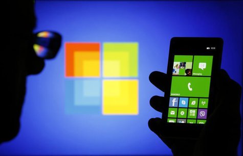 A man is silhouetted against a video screen with as he poses with a Nokia Lumia 820 smartphone in this photo illustration taken in the centr A man is silhouetted against a video screen with as he poses with a Nokia Lumia 820 smartphone in this photo illustration taken in the centr