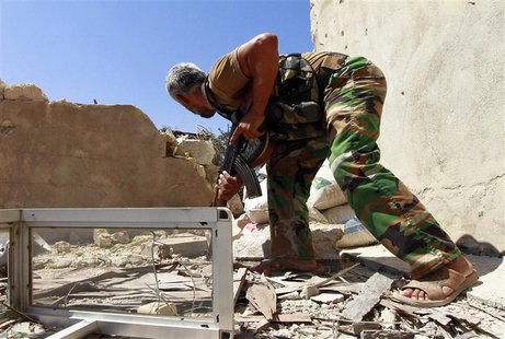 A Free Syrian Army fighter takes cover as he watches forces loyal to President Bashar al-Assad near Hanano Barracks in Aleppo, September 3, A Free Syrian Army fighter takes cover as he watches forces loyal to President Bashar al-Assad near Hanano Barracks in Aleppo, September 3,