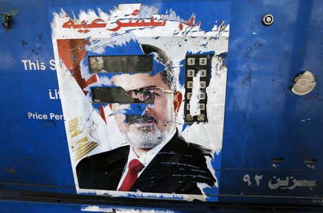 The remnants of a poster of ousted Egyptian President Mohamed Mursi are seen at a petrol station in Cairo August 28, 2013. REUTERS/Louafi La The remnants of a poster of ousted Egyptian President Mohamed Mursi are seen at a petrol station in Cairo August 28, 2013. REUTERS/Louafi La