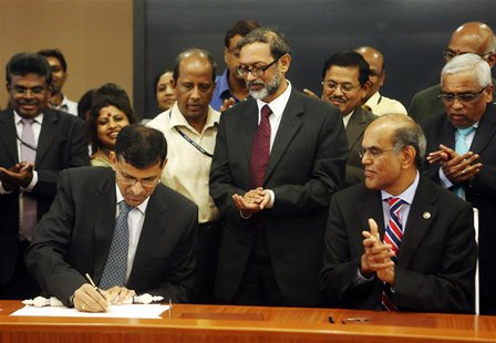 Raghuram Rajan (L), newly appointed governor of Reserve Bank of India (RBI), signs papers during the taking over ceremony at the bank's head Raghuram Rajan (L), newly appointed governor of Reserve Bank of India (RBI), signs papers during the taking over ceremony at the bank's head