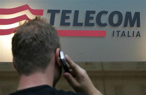 A man uses a mobile phone in front of a Telecom Italia shop in downtown Rome September 14, 2006. REUTERS/Dario Pignatelli A man uses a mobile phone in front of a Telecom Italia shop in downtown Rome September 14, 2006. REUTERS/Dario Pignatelli