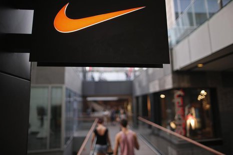 People walks past a Nike shop under the company logo at the Sanlitun shopping area in central Beijing, August 8, 2013. REUTERS/Petar Kujundz People walks past a Nike shop under the company logo at the Sanlitun shopping area in central Beijing, August 8, 2013. REUTERS/Petar Kujundz