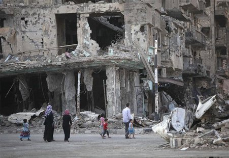 People walk along a damaged street filled with debris in Deir al-Zor September 4, 2013. Picture taken September 4, 2013. REUTERS/Khalil Asha People walk along a damaged street filled with debris in Deir al-Zor September 4, 2013. Picture taken September 4, 2013. REUTERS/Khalil Asha