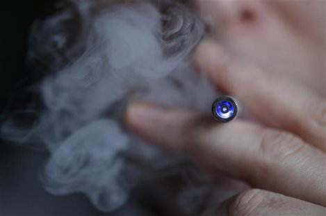 A man uses an E-cigarette, an electronic substitute in the form of a rod, slightly longer than a normal cigarette, in this illustration pict A man uses an E-cigarette, an electronic substitute in the form of a rod, slightly longer than a normal cigarette, in this illustration pict