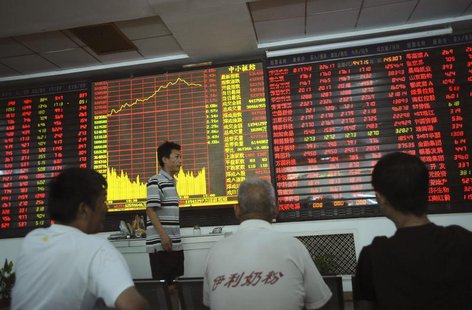 An investor walks past as others look at an electronic board showing stock information at a brokerage house in Wuhan, Hubei province July 11 An investor walks past as others look at an electronic board showing stock information at a brokerage house in Wuhan, Hubei province July 11